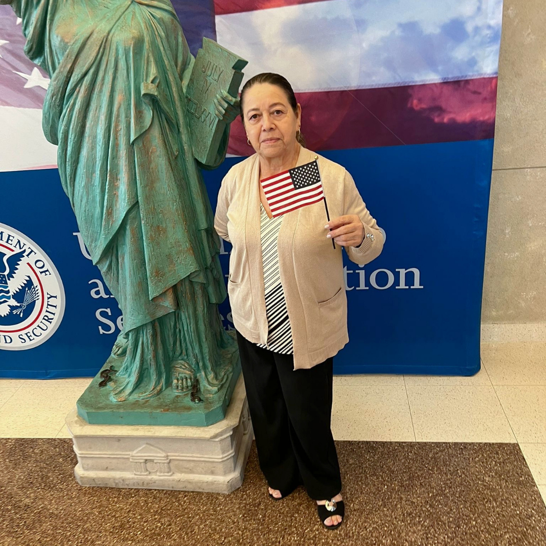 Nueva ciudadana con bandera en USCIS